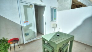 A small outdoor patio with a green table and a red chair. - Seafront Sea View Maisonette with Yards (St. Paul's Bay)