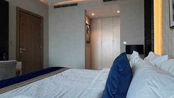 Une chambre d’hôtel avec un grand lit, une porte en bois et une petite table sur laquelle se trouve une machine à café.