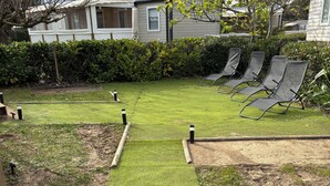A residential area with a well-maintained lawn, a pathway, and a row of outdoor chairs. - Mobile home 379, 4-star campground, Wi-Fi, AC (Lattes)