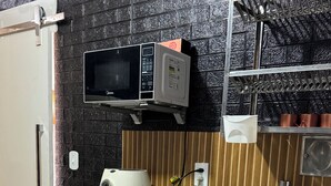 A compact kitchen with a microwave, kettle, and sink. - Close to everything, with comfort and security. (Rio de Janeiro)