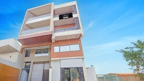 Un immeuble à plusieurs étages, doté d’une enseigne entretenue par l’entreprise, de grandes fenêtres et d’une entrée sécurisée par un portail.