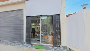 Un bâtiment doté d’une porte à volet roulant, d’une entrée en verre et d’un sol carrelé.