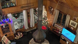 Ein gemütliches Interieur mit Kamin, Fernseher und Weihnachtstann.