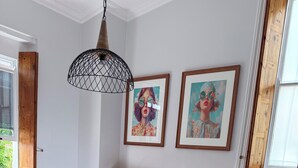 A bedroom with a bed, two pillows, a nightstand, a lamp, and two framed pictures on the wall. - Peaceful 2-bedroom apartment in charming Mossel Bay perfect for relaxing (Mossel Bay)