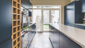 Een moderne keuken met een centraal eiland, inbouwkasten en uitzicht op buiten.