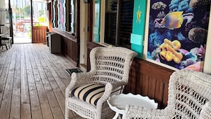 A wooden deck with wicker chairs and a mural of fish. - 106 Deluxe Studio Suite in waterfront hotel in Singer Island, FL (Riviera Beach)