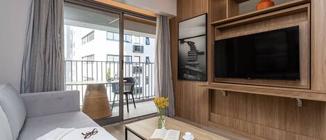 A modern living room with a sofa, coffee table, and a TV mounted on a wooden wall.