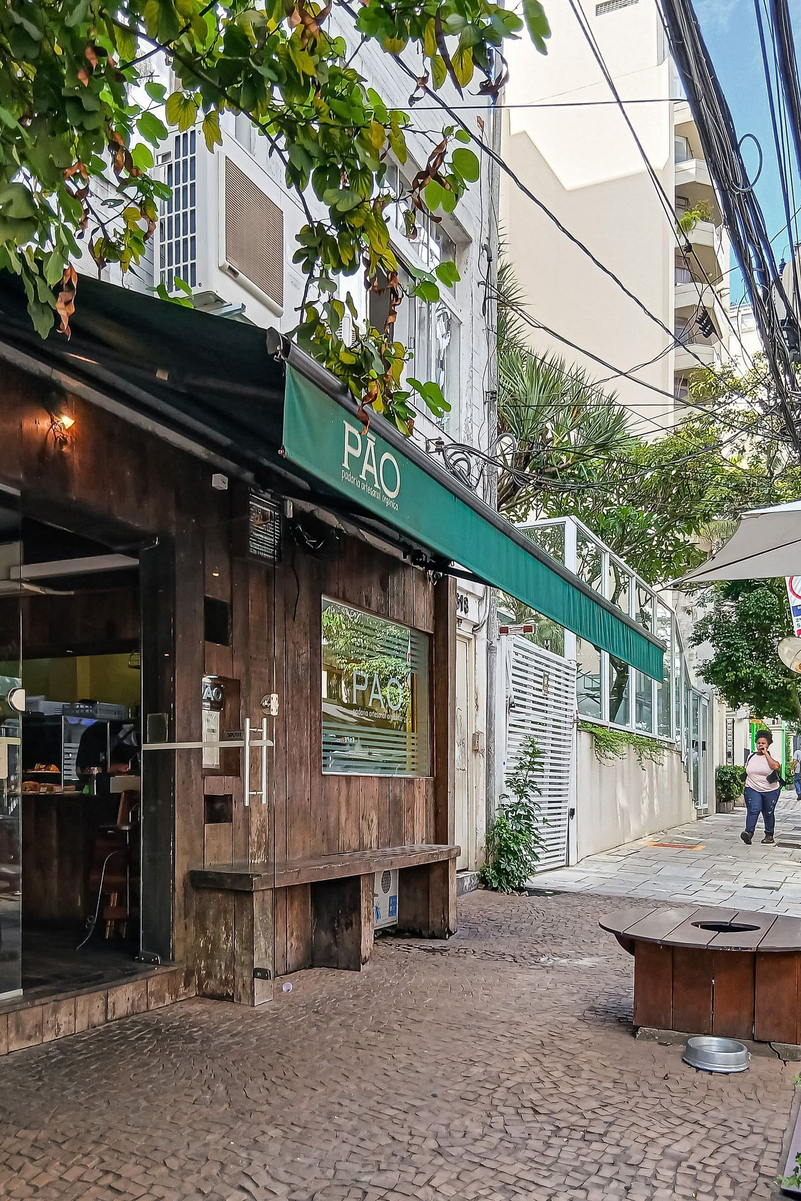A building with a green awning labeled 'PAO' and a sign with a landscape image.
