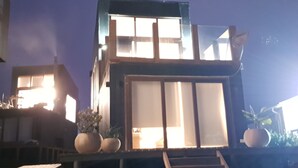 Un moderno edificio de dos pisos con amplias ventanas y una escalera que conduce al nivel superior.