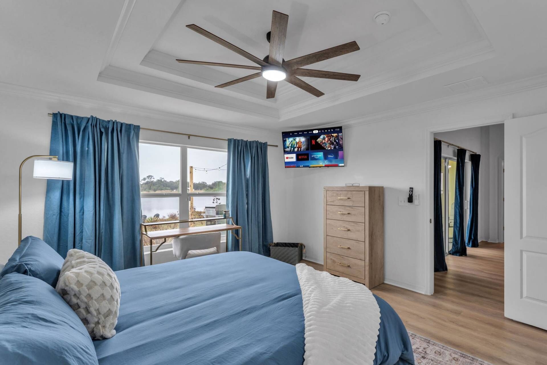 A bedroom with a bed, a desk, a TV, and a wardrobe.