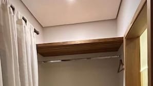 A bedroom with a bunk bed, a small window, and a door.