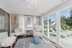 A room with a desk, chair, and lounge chairs by a large window. - Waterfront Getaway with Boat Slip (Ocean Pines)