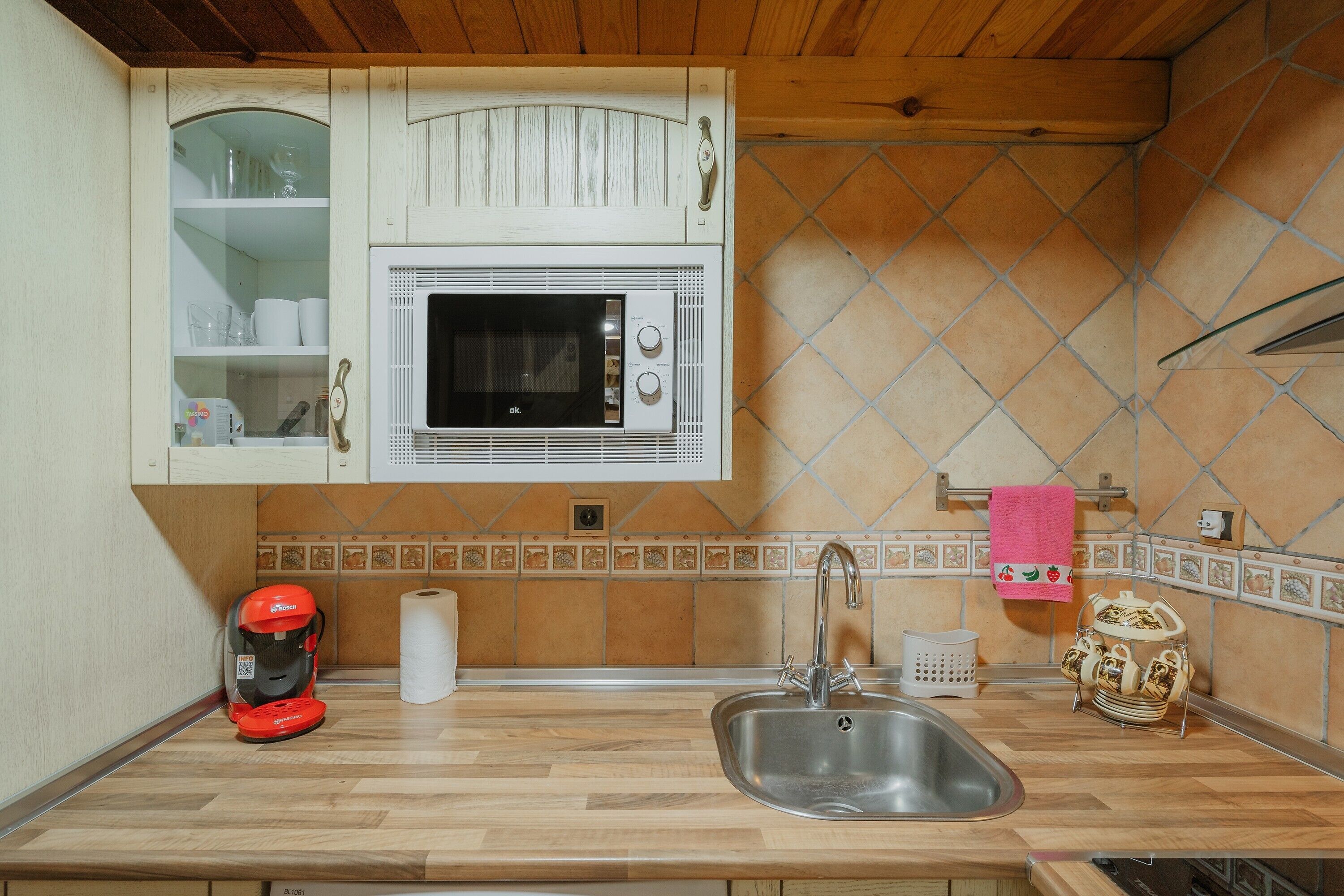 A kitchen with a microwave, sink, and a coffee maker.