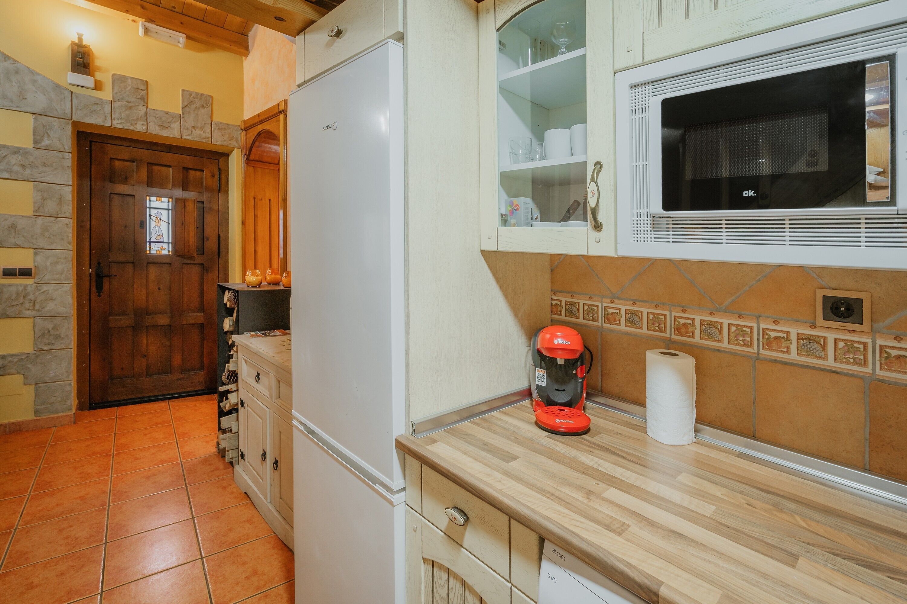 Eine Küche mit Kühlschrank, Mikrowelle und Kaffeemaschine.