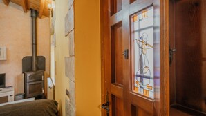 A wooden door with a stained glass window, a fireplace, and a bed with a headboard.