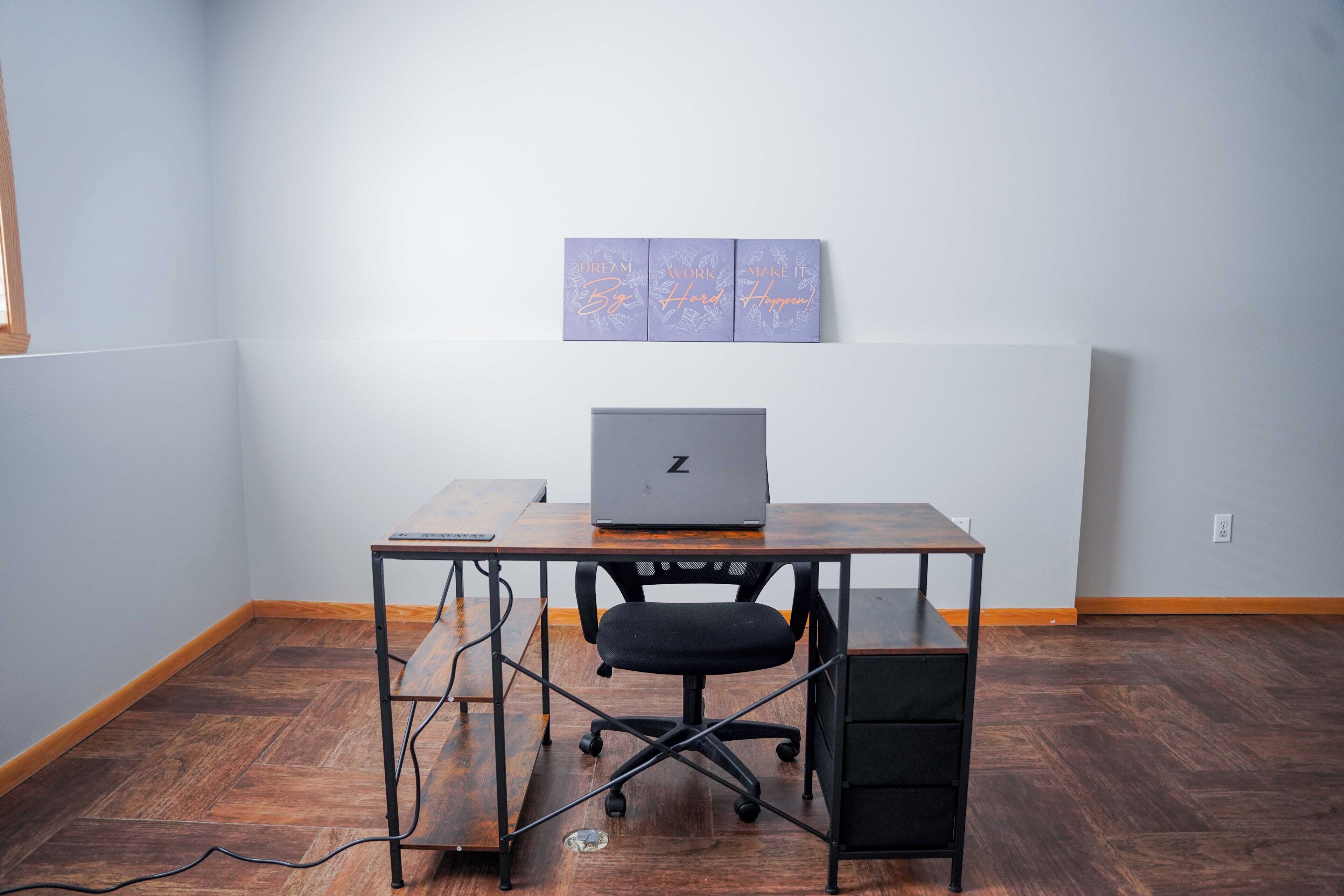A workspace with a desk, chair, and laptop.