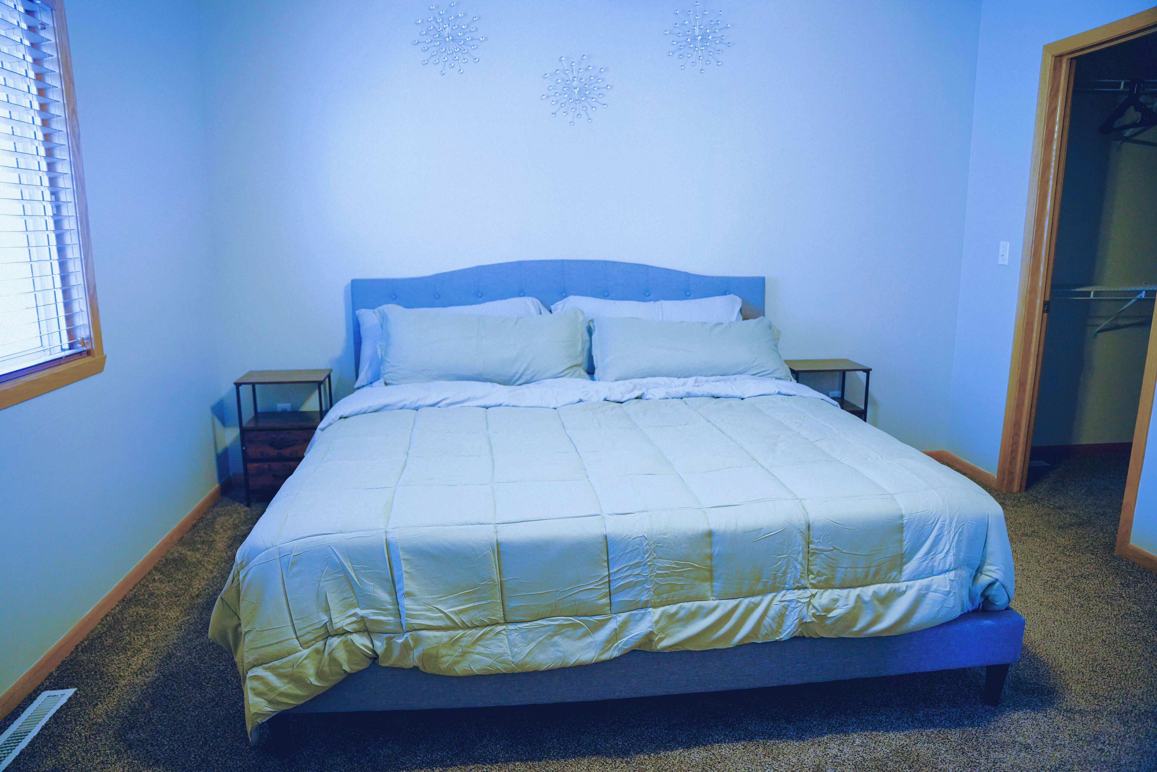 Ein Schlafzimmer mit einem Bett, Nachttischen und einem Fenster.