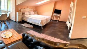 Une chambre à coucher comprenant un lit, un bureau, une chaise, un canapé et un miroir.