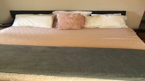 A bed with a black headboard, white and pink pillows, and a grey accent pillow. - Stay Where Tampa Comes Alive - Central Home Near Events & Attractions (Tampa)