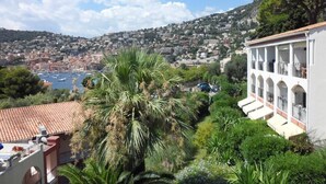 A coastal town with a view of the sea and a building with a balcony. - Apartment Ange Gardien, swimming pool, panoramic sea view in Villefranche sur Mer (Villefranche-sur-Mer)
