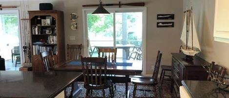 A kitchen with a dining area, a bookshelf, and a sailboat decoration.