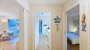 A hotel corridor with a dining area on the left, a kitchenette in the center, and a bedroom on the right. - HENRI CAMILLE RE - Passy1 -Beautiful one bedroom swimming pool and parking (Cannes)