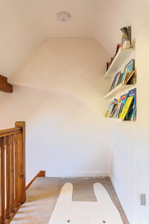 A staircase with a wooden handrail leading to a landing.