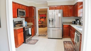 Una cocina moderna con armarios de madera, electrodomésticos de acero inoxidable y una isla central.