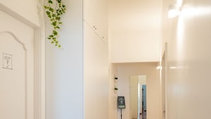 Een gang met een marmeren vloer, witte muren en een deur met de tekst 'Room 3'.