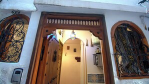 An arched doorway with intricate metalwork, a small sign, and a tiled wall. - Studio M - Tiny house kesbah de tanger (Tanger)