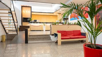 Un intérieur moderne avec un escalier, un canapé rouge et un coin cuisine.