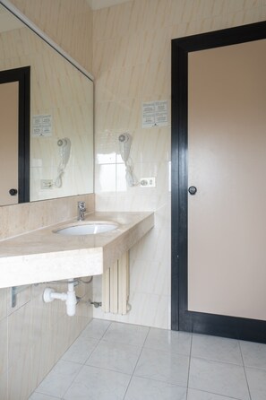 A bathroom with a sink, mirror, and a door. - Hotiday Cagliari Sant'Elena (Quartu Sant'Elena)