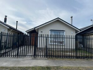 A row of single-story mobile homes with a black metal fence in front. - Cozy Shelter with Excellent Connectivity (Downtown and Airport) (Los Lagos)
