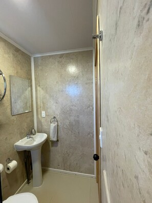 A bathroom with a sink, toilet, and a shower area. - Cozy Shelter with Excellent Connectivity (Downtown and Airport) (Los Lagos)