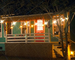 Un edificio con tejado de paja, escalera de madera y luces colgantes.