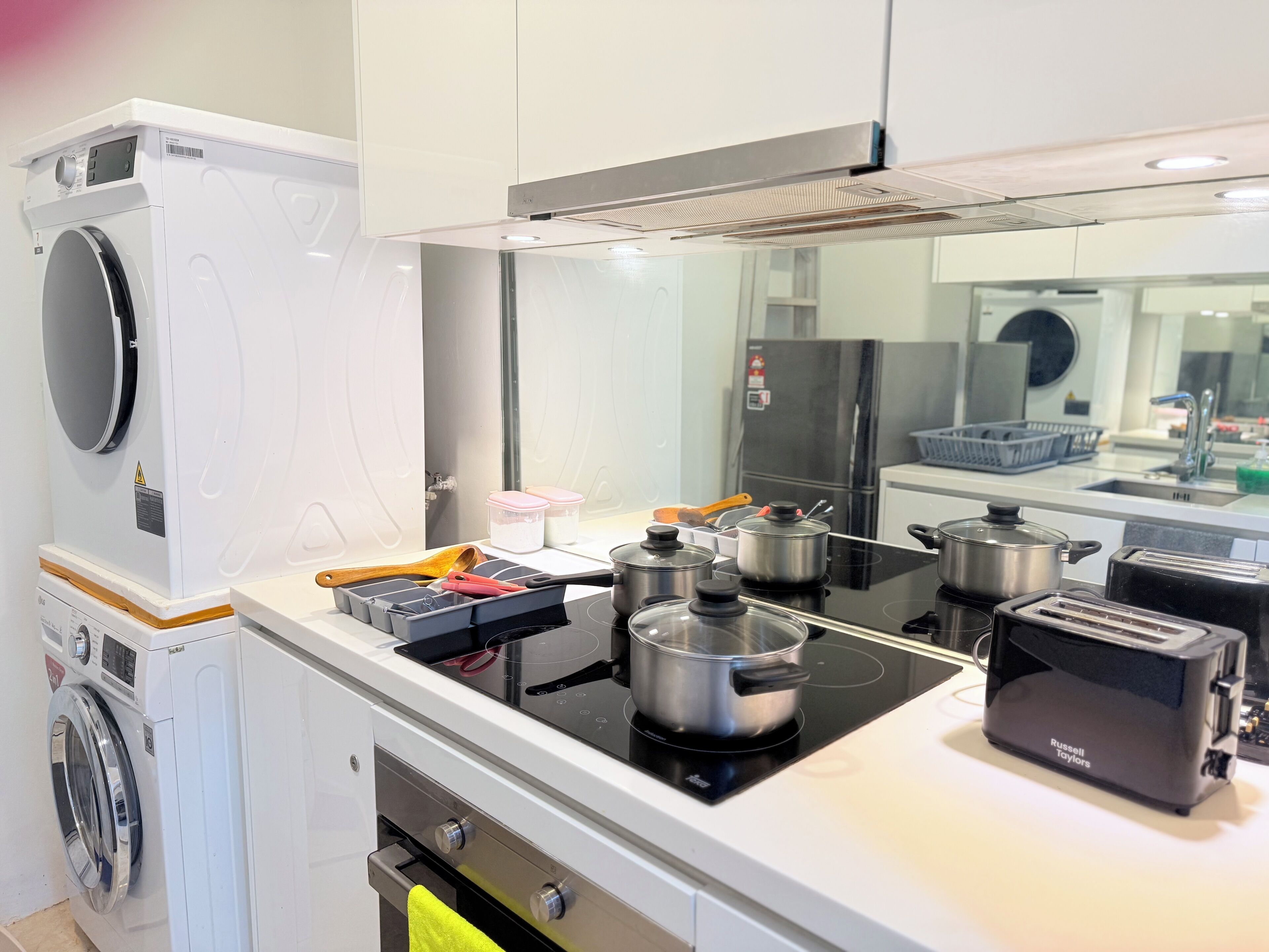 A modern kitchen with a built-in washer, stove, and refrigerator.