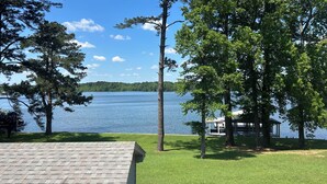 A lakeside view with a gazebo, grassy areas, and trees.