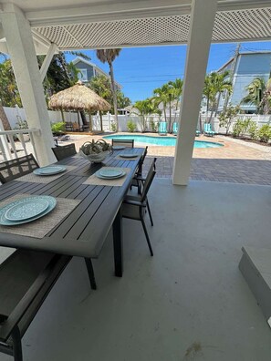Une terrasse extérieure avec une piscine, des coins salon abrités et une vue sur l’océan.