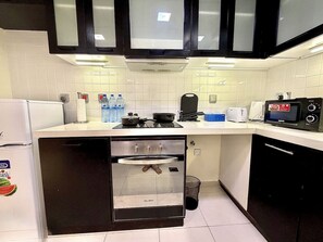 Eine kleine Küche mit Backofen, Mikrowelle und Toaster.