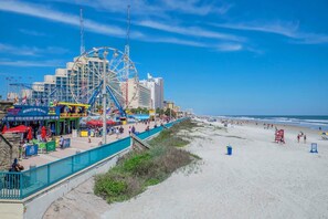 A beachside amusement park with a Ferris wheel, beach umbrellas, and a boardwalk. - Daytona Beach XII (Daytona Beach)