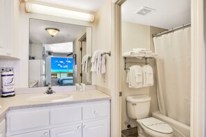 A bathroom with a sink, mirror, towel rack, and toilet. - Daytona Beach (Daytona Beach)