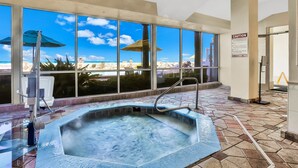 Ein Whirlpool mit Blick auf den Strand, große Fenster und ein Warnschild.