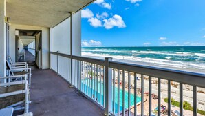 Ein Balkon mit Blick auf den Ozean und ein Poolbereich.