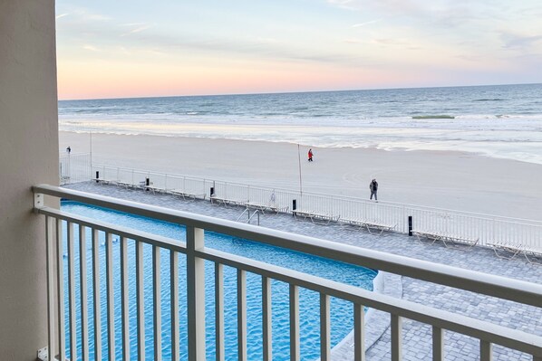 Blick auf einen Pool mit Strand im Hintergrund.