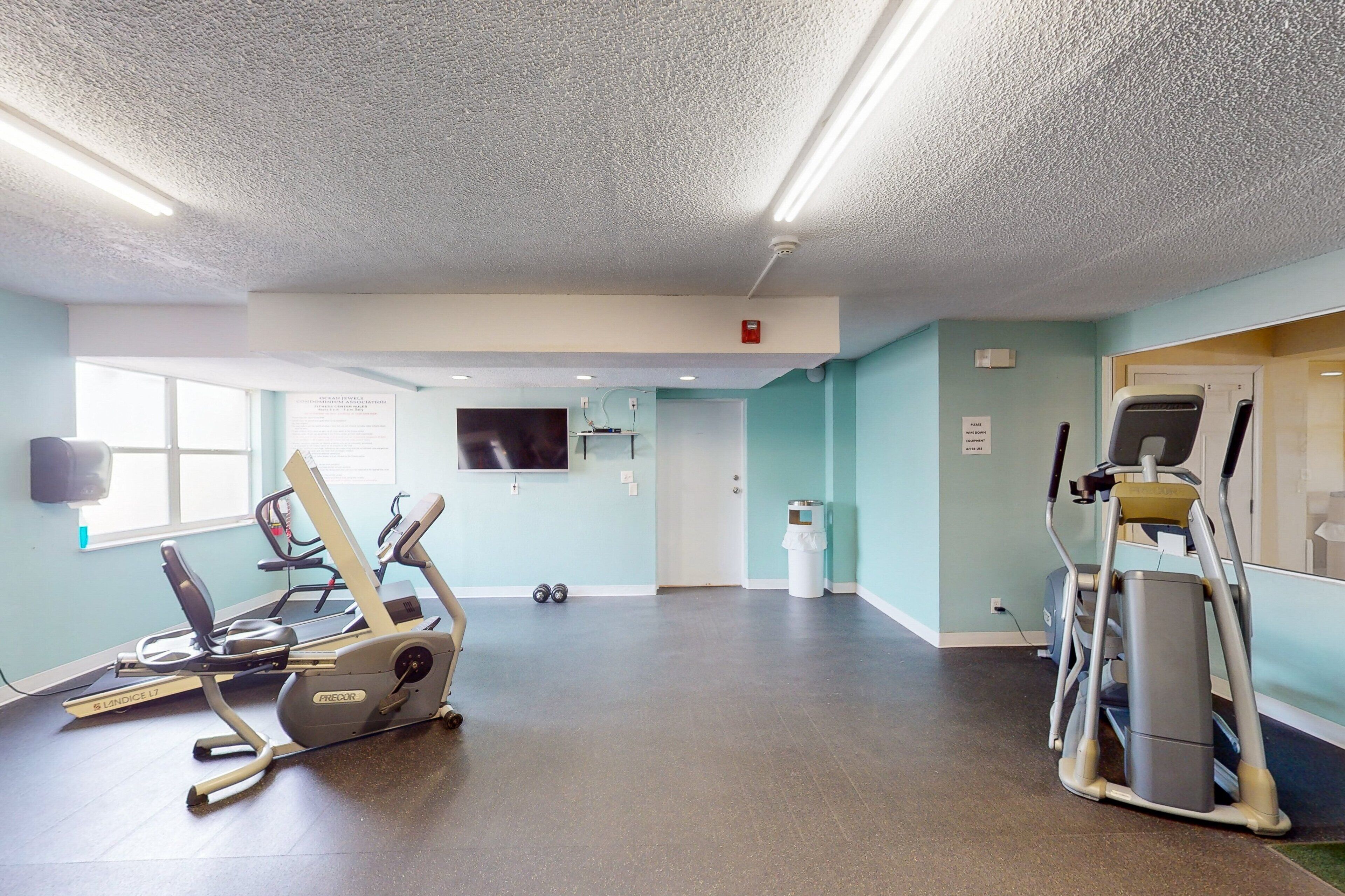 A fitness room with treadmills, an elliptical, and a stationary bike.