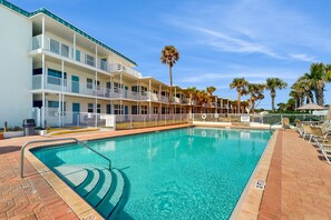 A swimming pool with a clear blue water, surrounded by a brick walkway. - Daytona Ocean Jewels (Daytona Beach)