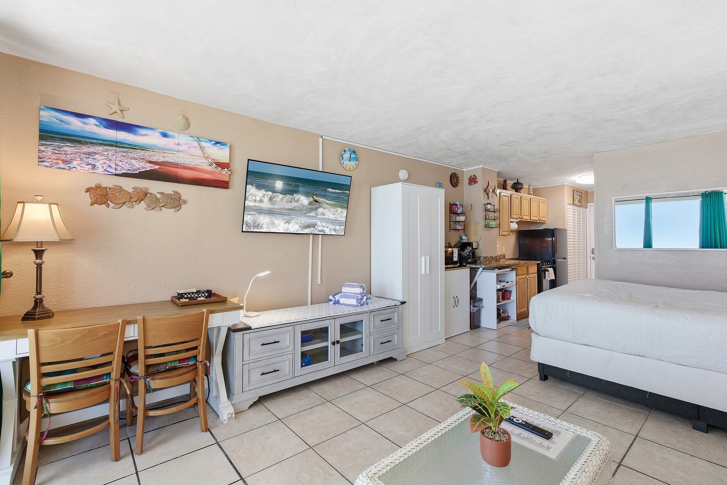 Un espacio habitable compacto con comedor, kitchenette y cama.