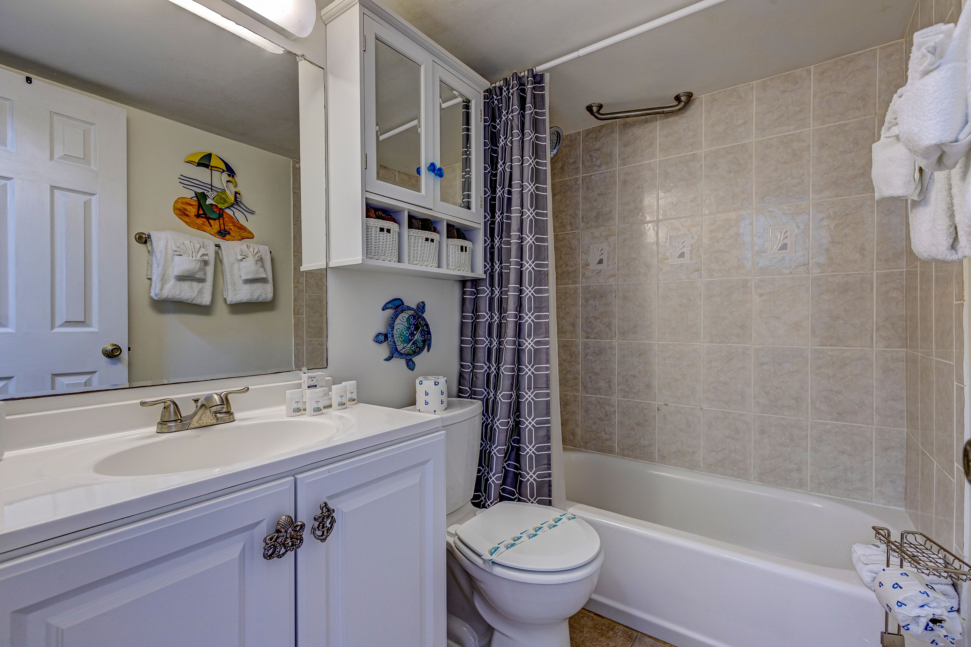 Une salle de bain avec un lavabo blanc, des toilettes, une baignoire et un rideau de douche.