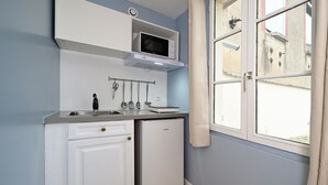 A compact kitchen with a microwave, a small refrigerator, and a sink. - Studio Cocon Landon - Studio Apartment, Sleeps 2 (Château-Landon)