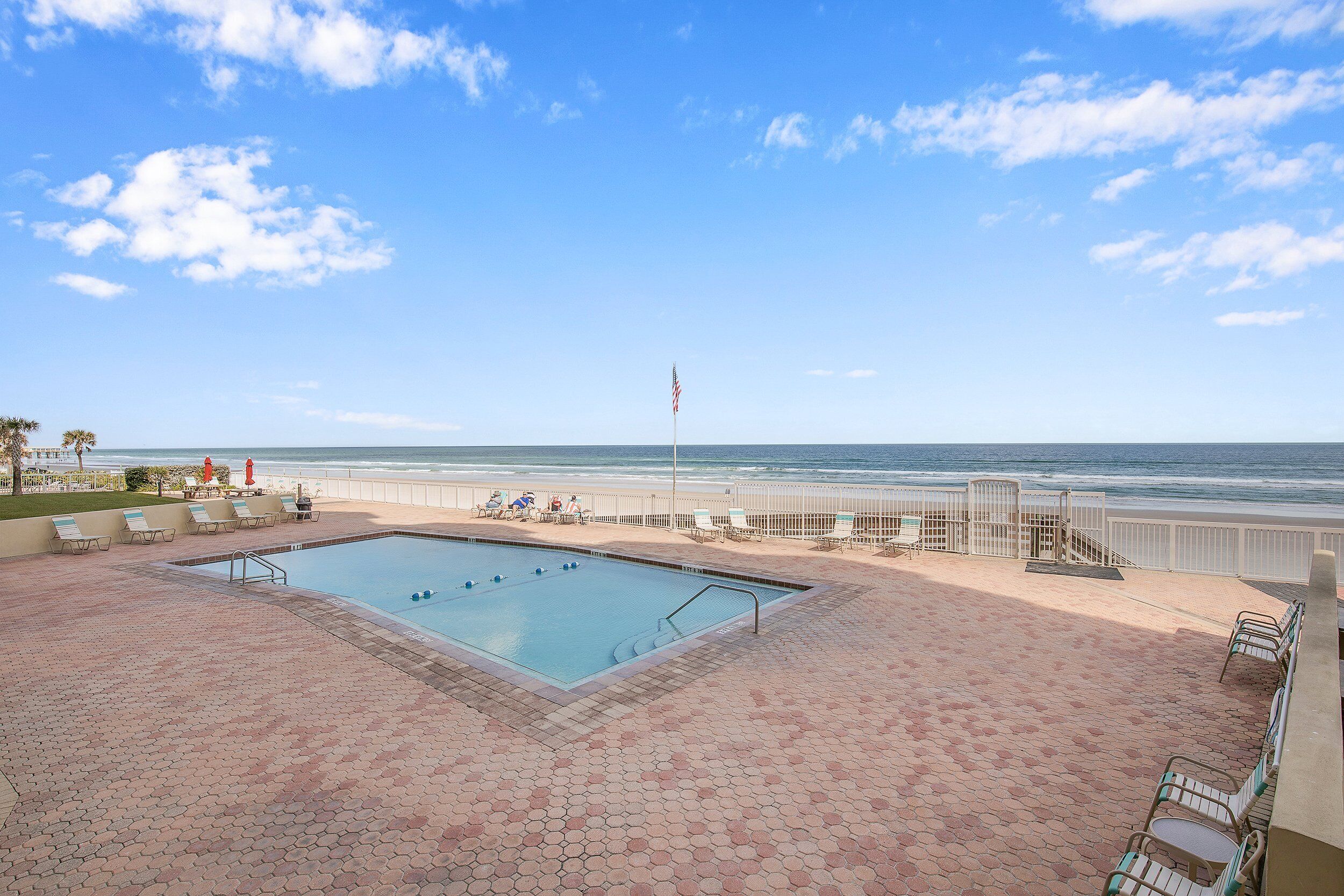 A swimming pool with a view of the beach and ocean.